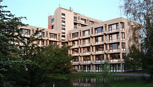 Bild vom Gebäude 24.21 auf dem Campus Süd. Ein Gebäude mit drei Flügeln und 6 Etagen mit einem Teich im Vordergrund.
