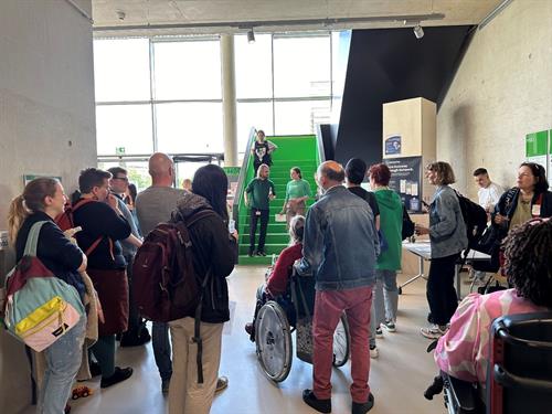 Das Foto zeigt unterschiedliche Personen, die am Disability Pride Day an der HSD teilnehmen. In der fotografierten Szene werden von den Organisator*innen Informationen an die Teilnehmer*innen kommuniziert.