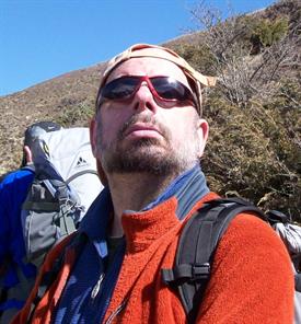 Thomas Münch mit Sonnebrille auf einer Rucksacktour durch die Berge.